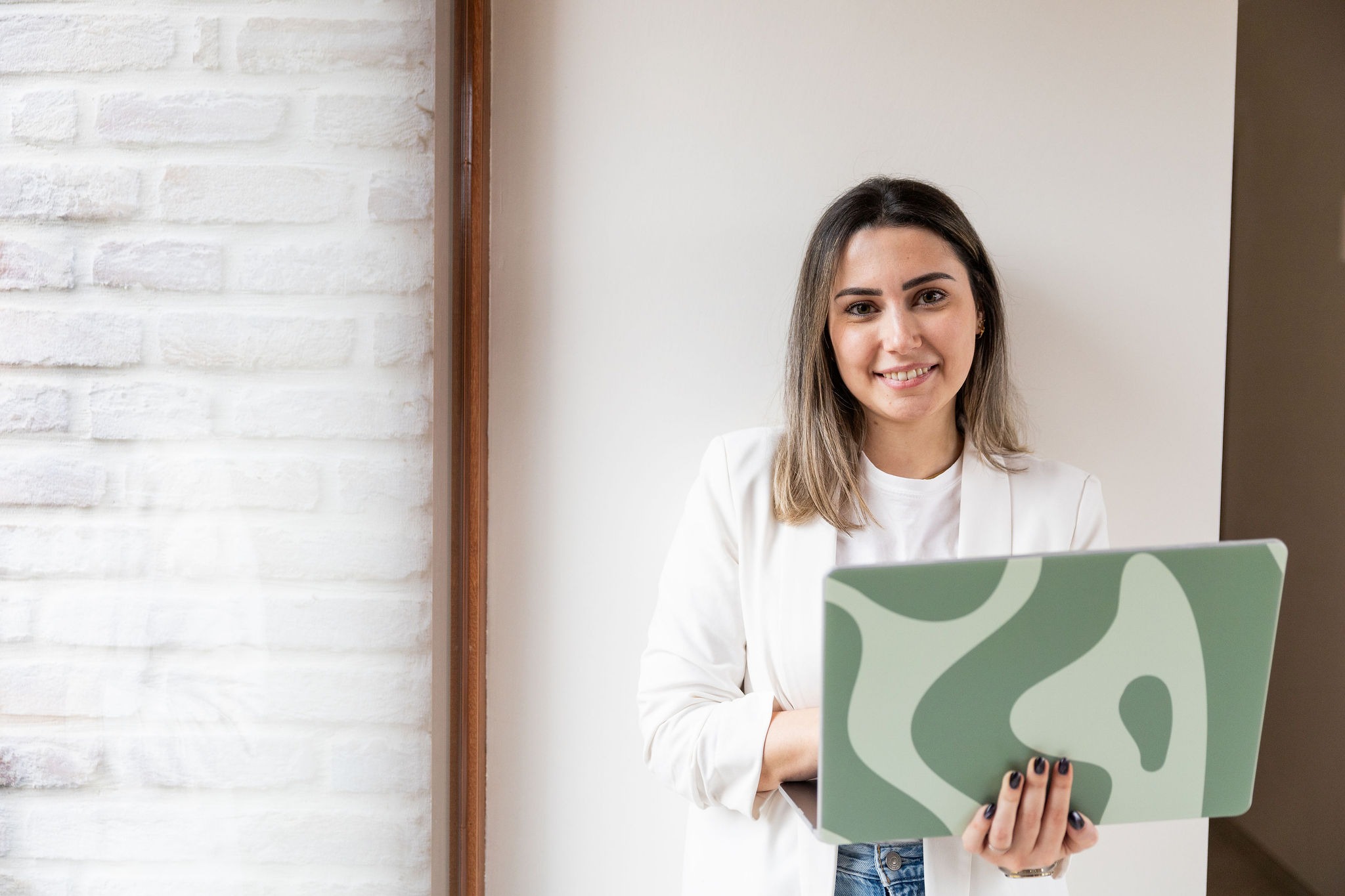 Strakke werkplek met een extern beeldscherm en half geopende laptop, symbool voor technische koppelingen en digitale ondersteuning.