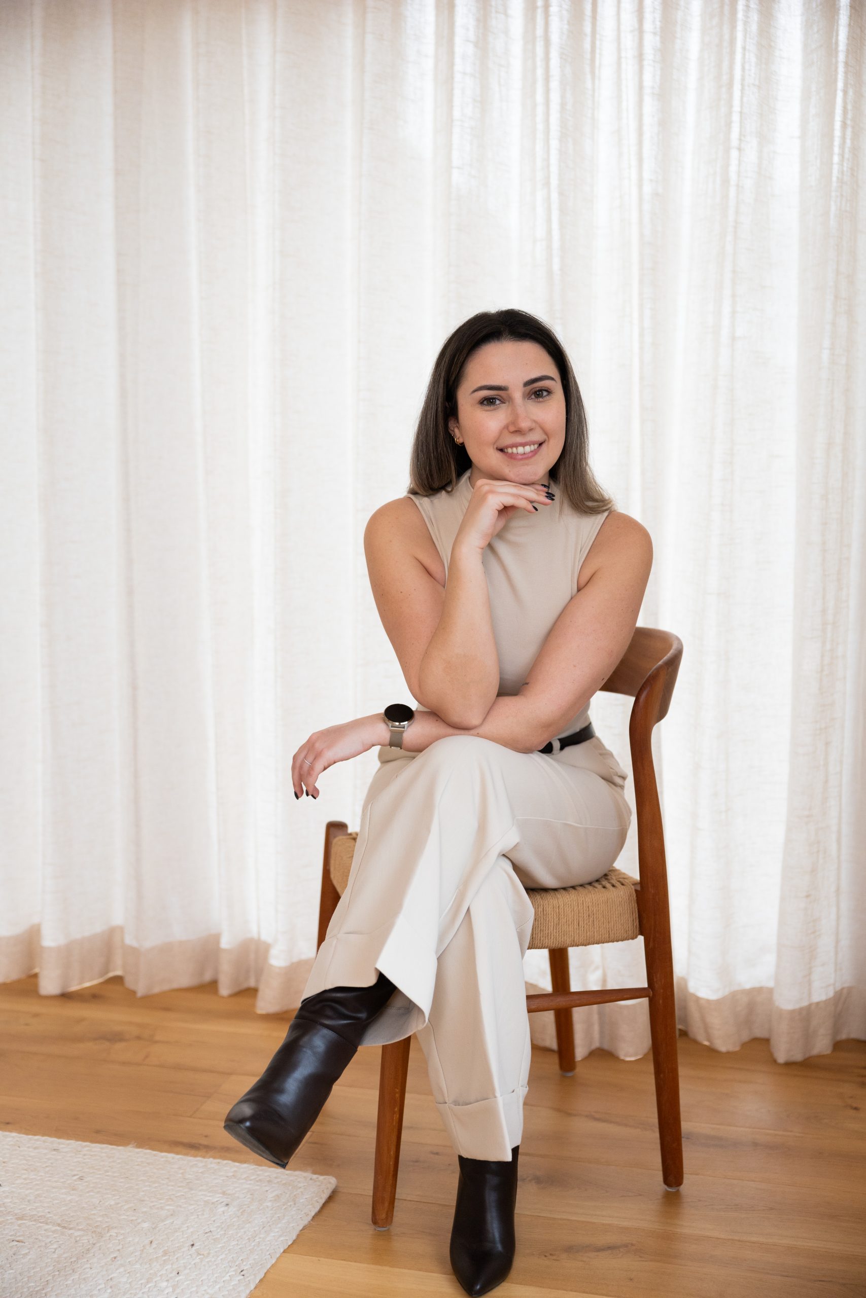 Sylke, virtual assistant, zittend op een bruine stoel