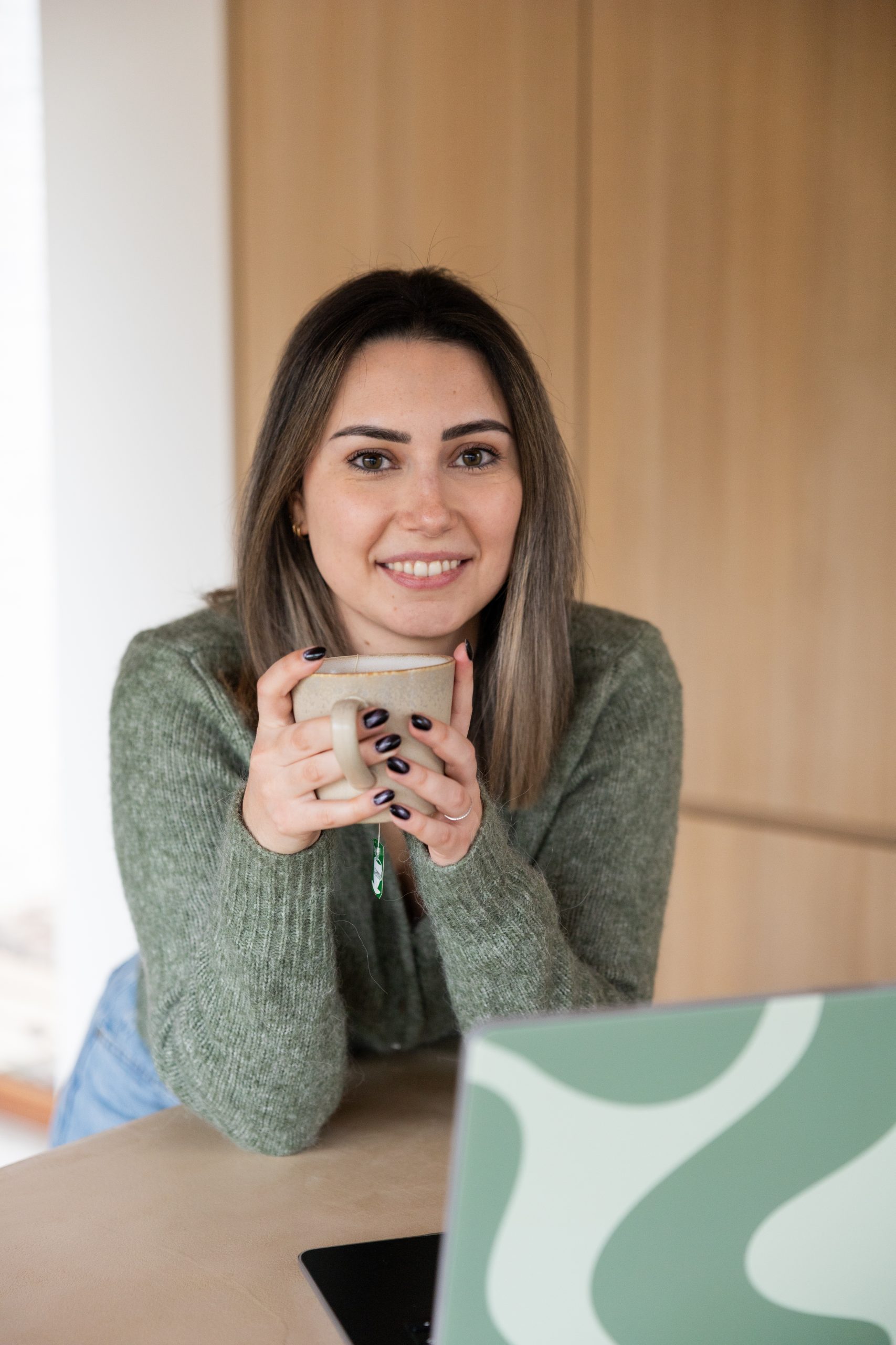 Sylke, virtual assistant, ontspannen met een koffie tijdens het werk